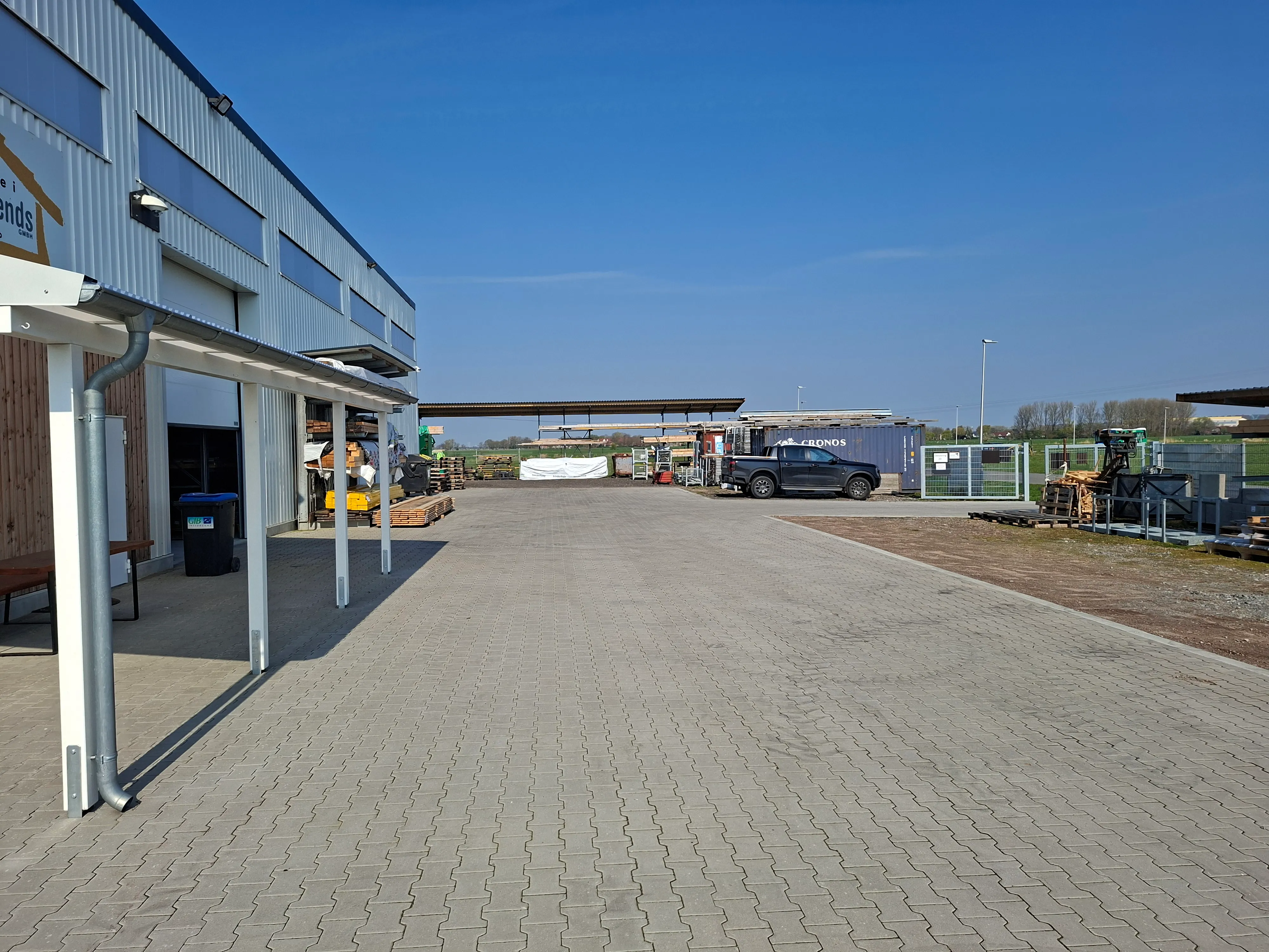 Hof der Zimmerei mit Materiallager und Fuhrpark